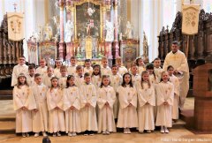 Bild mit Pfarrer Dr. Pitour und allen Erstkommunionkinder nach der feierlichen Messe vor dem Chorraum.